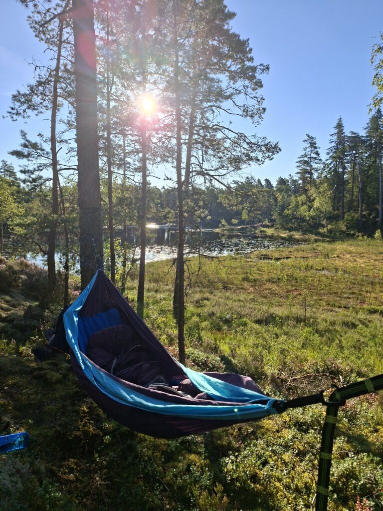 Hängmatta eller hammock vid en sjö ger bästa förutsättningar för en natt i naturen